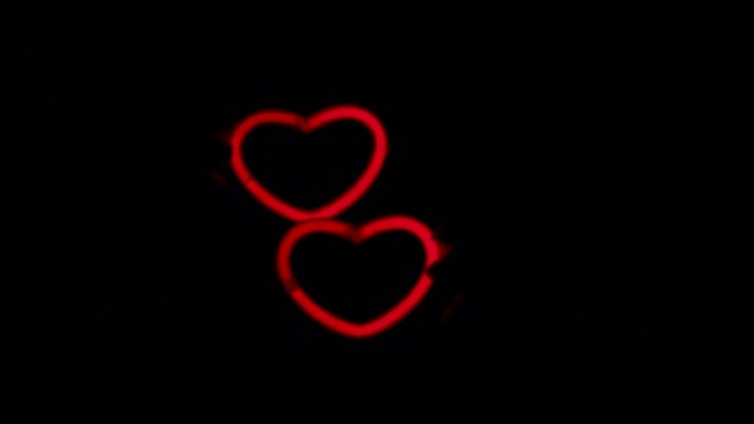 黑色背景上的红色霓虹灯心。两颗霓虹灯的心一起跳舞。