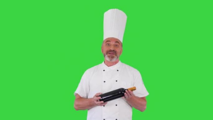 穿着制服的厨师拿着一瓶葡萄酒，在绿色屏幕上与您谈论它，色度键