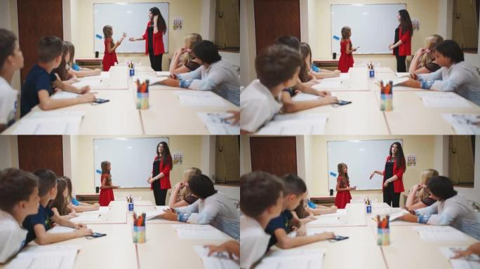 女教师给一个年轻的女学生做记号笔，在黑板上写下答案