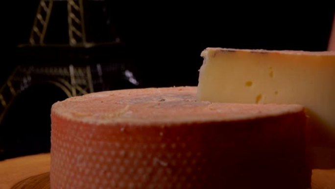 手从木板上的奶酪轮中取出一块硬奶酪