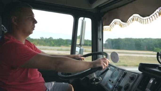 卡车司机手握方向盘，控制卡车驶向目的地。男子在乡下驾驶汽车。卡车司机在乡间道行驶。物流运输概念。