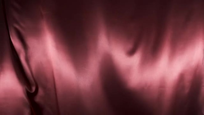 红色织物在风中飘扬。慢动作。波浪形缎纹织物在风中飘扬。抽象丝缎面料