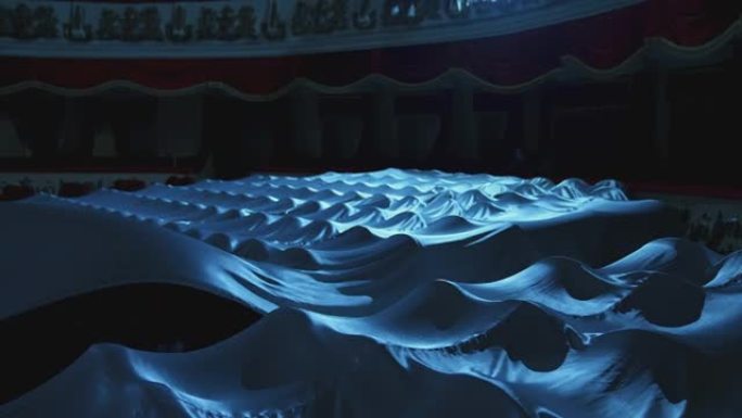 黑暗中的剧院大厅。表演结束后，空剧院的座位被白布覆盖。