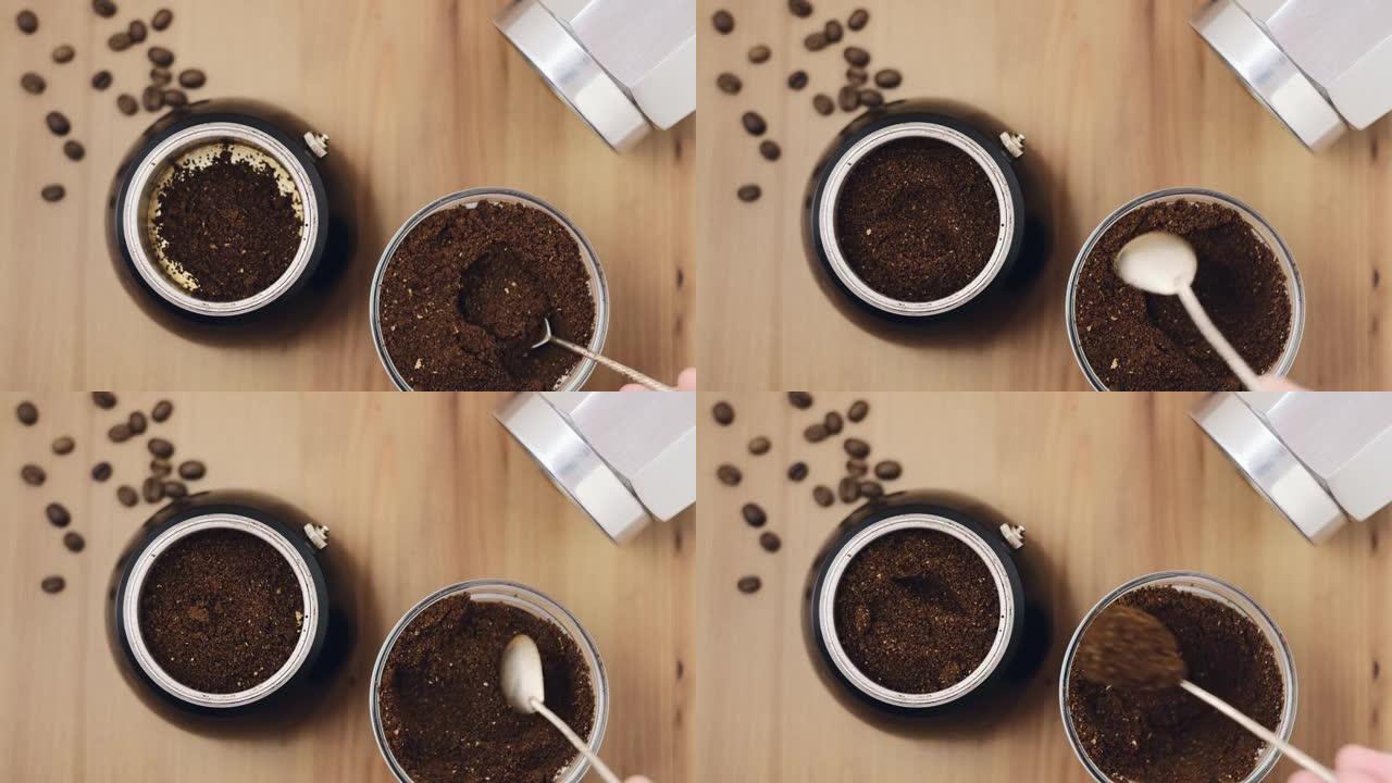 在金属意大利咖啡壶中冲泡浓缩咖啡。磨碎的阿拉比卡咖啡豆，勺子装入咖啡壶，俯视图放在木桌上。咖啡店煮咖