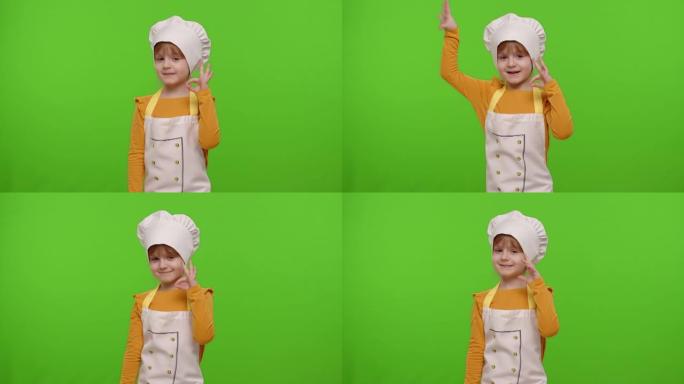 穿着围裙的小女孩，像厨师厨师一样，显示批准好的标志，美味的手势，色度键