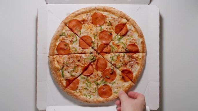 人的手从纸盒里拿出一片披萨