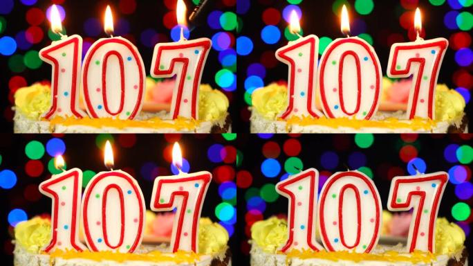 107号生日快乐蛋糕与燃烧的蜡烛顶。