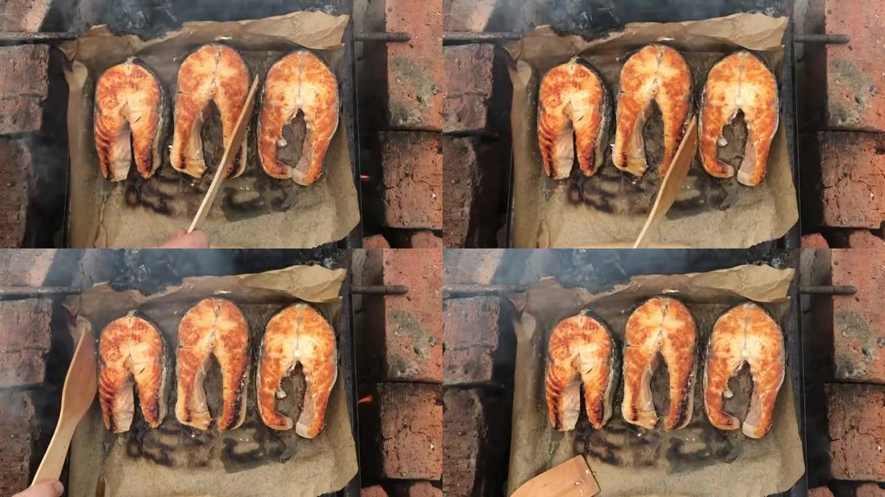 在火上烤鲑鱼排。房子院子里着火的烤鱼