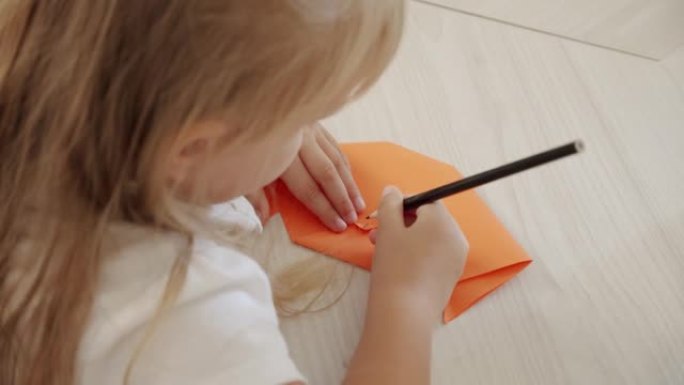 幼儿园或家里的女孩用纸画一个图形。