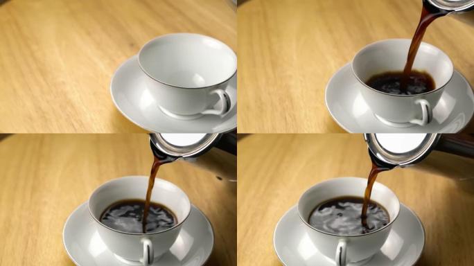 将黑咖啡倒入木制桌子上的带碟子的白色陶瓷杯中。
