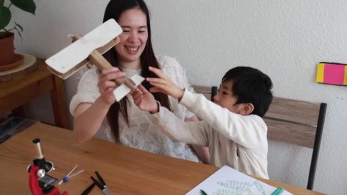 亚洲母子俩在家与木飞机一起玩耍-家庭，母亲和孩子的爱