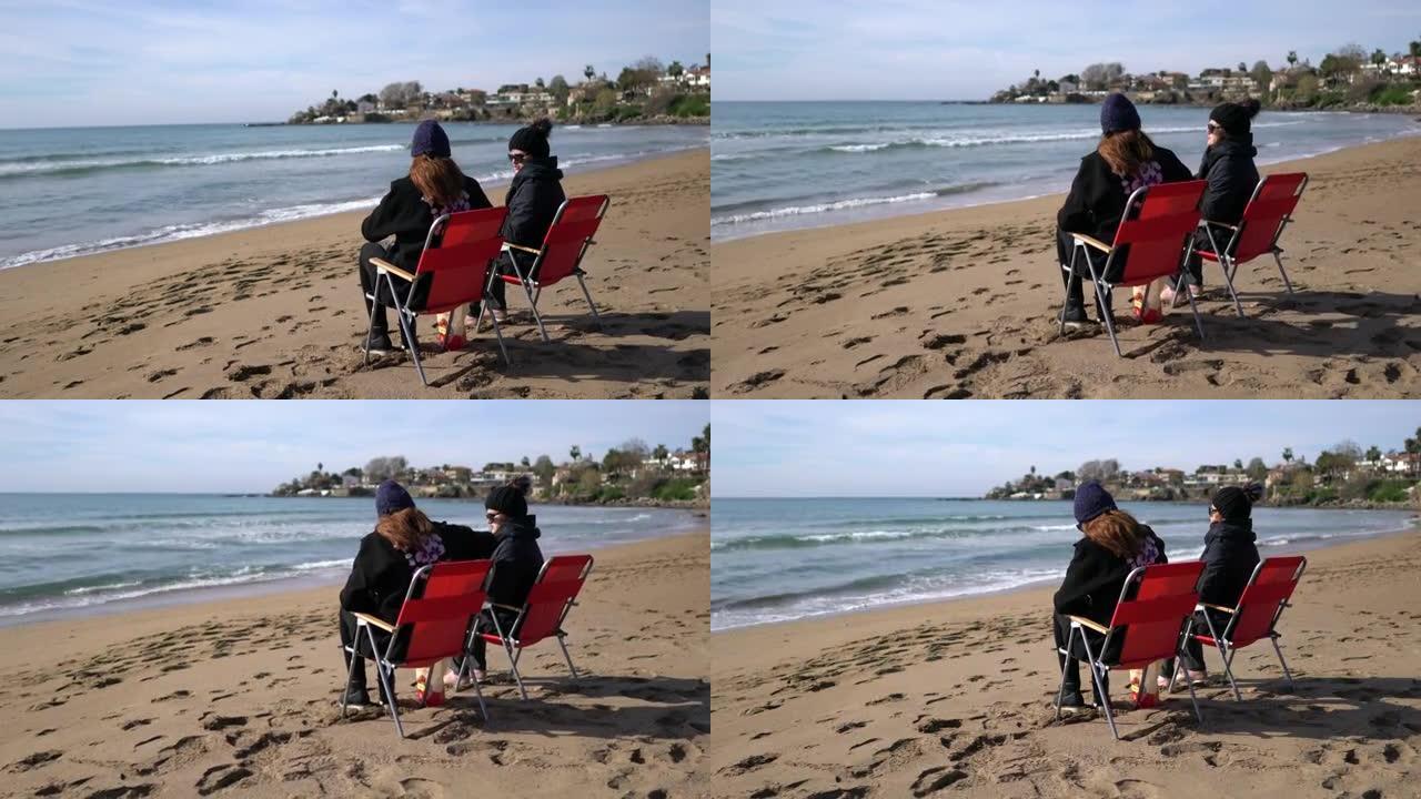 两名中年妇女冬天坐在沙滩上