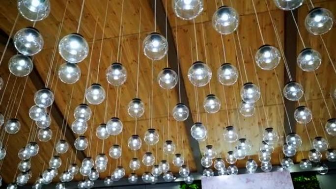 许多灯具的创意内饰。室内悬挂灯泡的现代天花板照明。