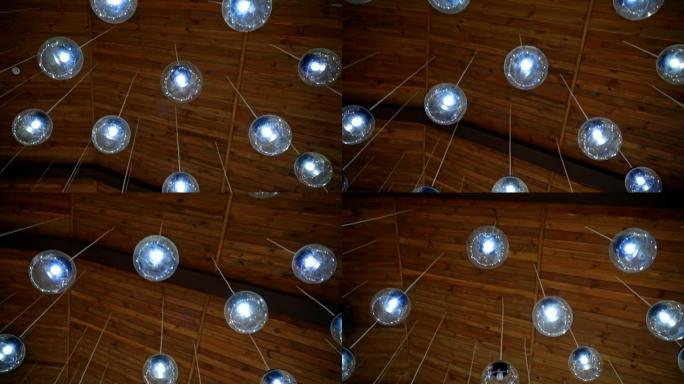现代天花板照明。棕色背景，白色电线上悬挂着漂亮的圆形玻璃球灯。房间的豪华设计。