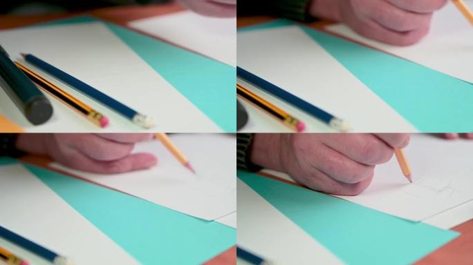 hand用手从桌子上拿一支铅笔，开始画画。设计师在工作。