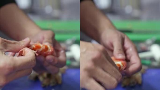 厨师从一只大龙虾上取下贝壳。垂直视频。特写。