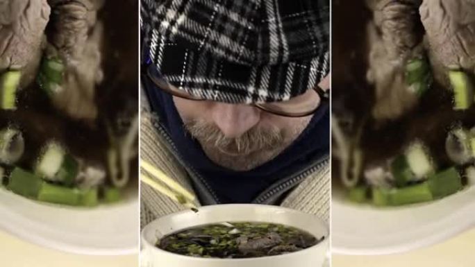 男人从碗里吃河粉汤筷子。