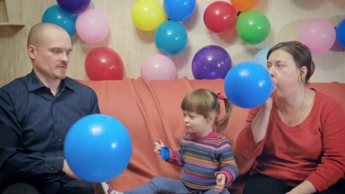 爸爸，妈妈和小女孩蓝色充气气球过生日