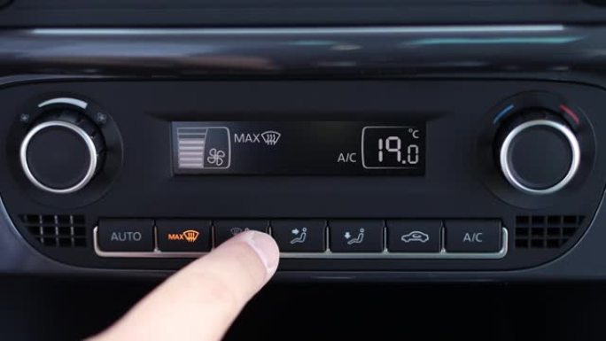 用手调节车内的空调控制按钮