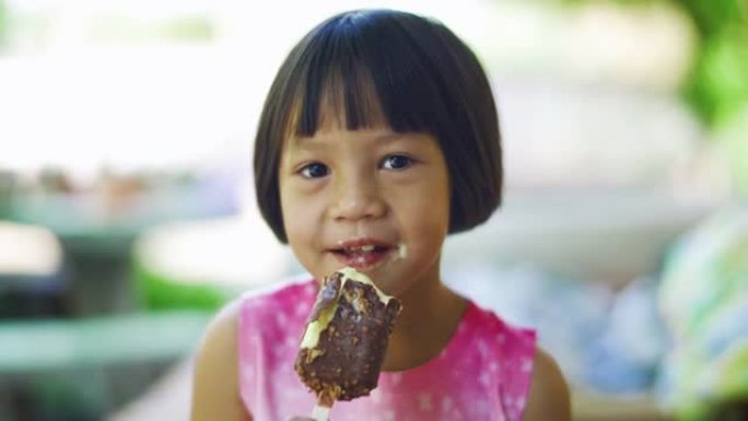 可爱的女孩正在吃巧克力冰淇淋零食，带着积极的情绪，放松和享受饮食。