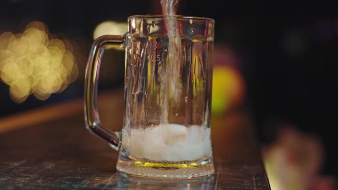 镜头特写镜头慢动作冷啤酒倒入一杯啤酒会产生气泡