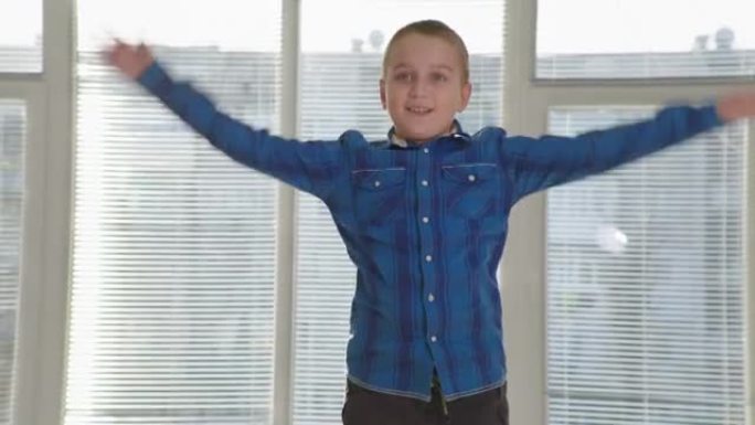 健康的生活方式，积极快乐的孩子男孩举手，在蹦床上跳起来很开心