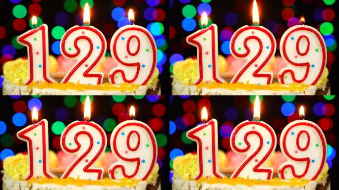 129号生日快乐蛋糕与燃烧的蜡烛顶。