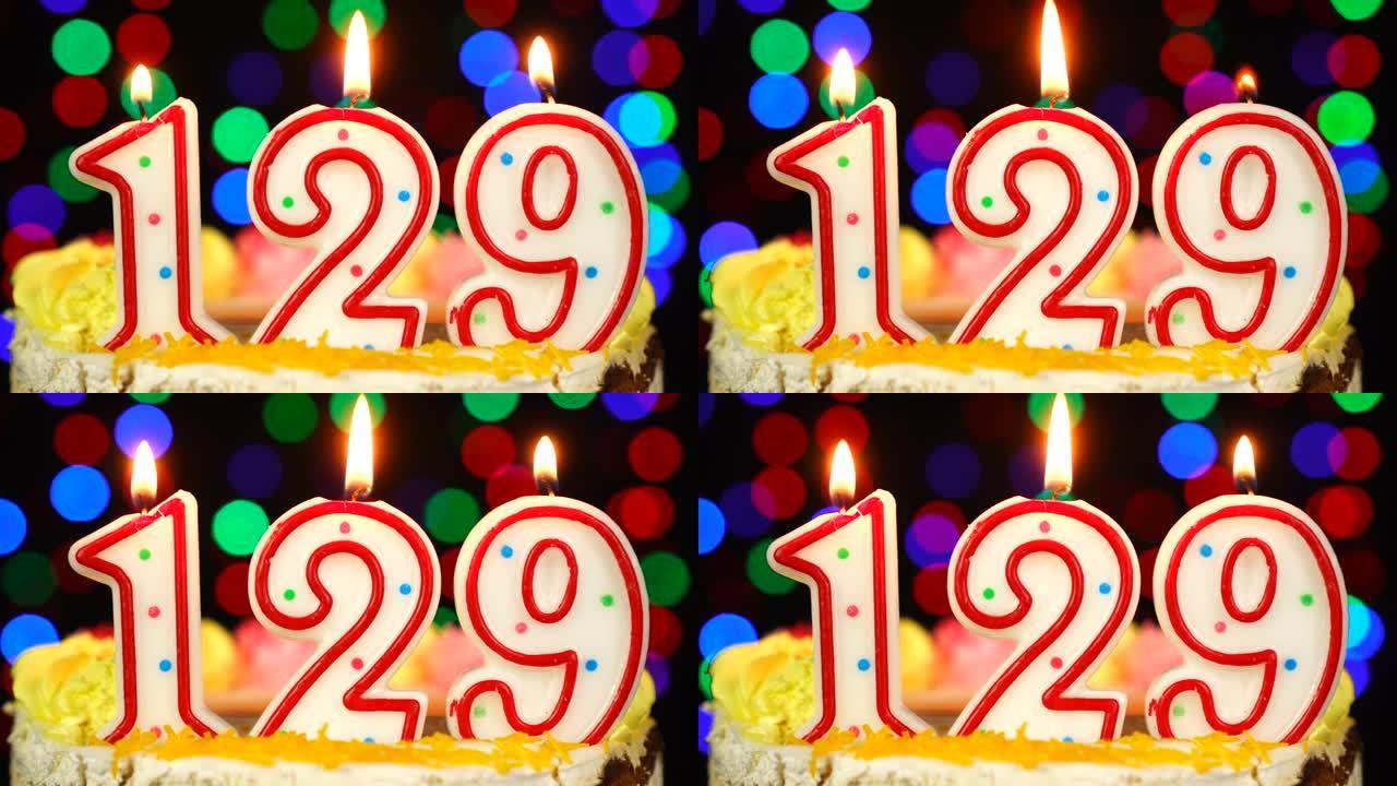 129号生日快乐蛋糕与燃烧的蜡烛顶。