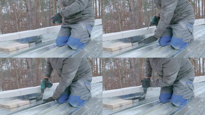 屋顶工用螺钉固定屋顶的镀锌铁片。