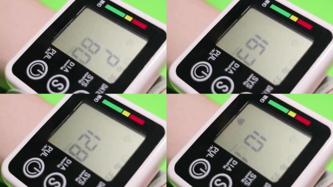 一个人通过自动数字眼压计测量血压。特写。绿色背景上的视频。全高清。