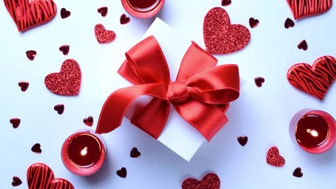 情人节: 红色的爱心，浪漫的礼品盒，白色背景上的蜡烛。带有复制空间的浪漫消息模板。平面布局，俯视图，