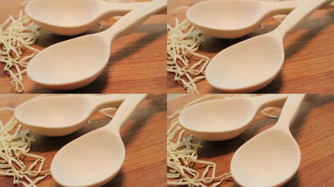 木桌上的木勺。用木头做餐具的古老技巧。平稳旋转。