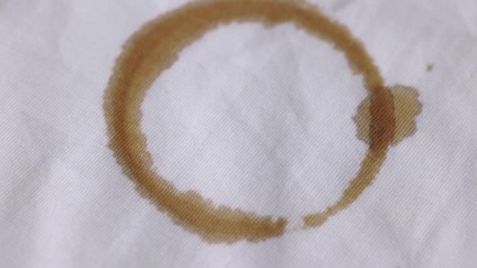 一件沾有棕色咖啡渍的白色棉质衬衫。必须在洗衣机中彻底清洗