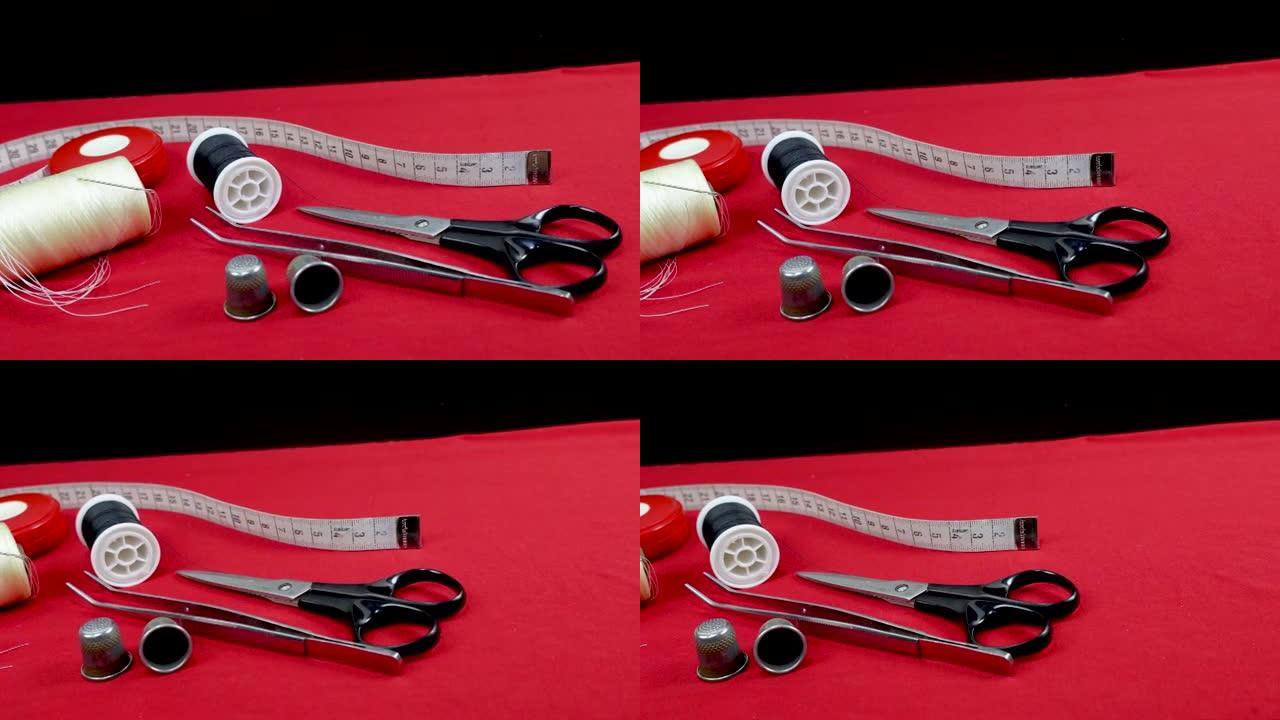 缝纫工具、顶针、线、剪刀对抗红色织物