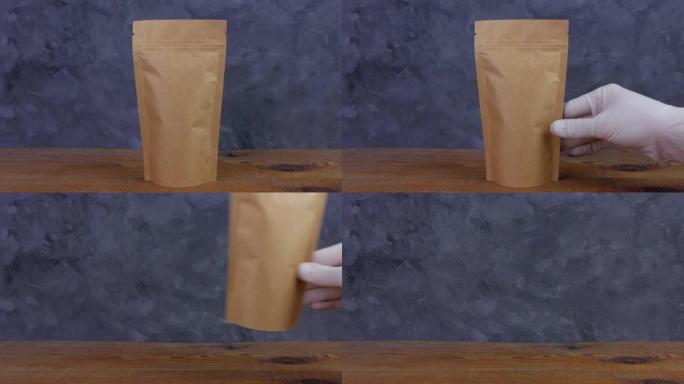 木质背景上的咖啡豆棕色牛皮纸袋袋顶视图。食品包装镜头4K