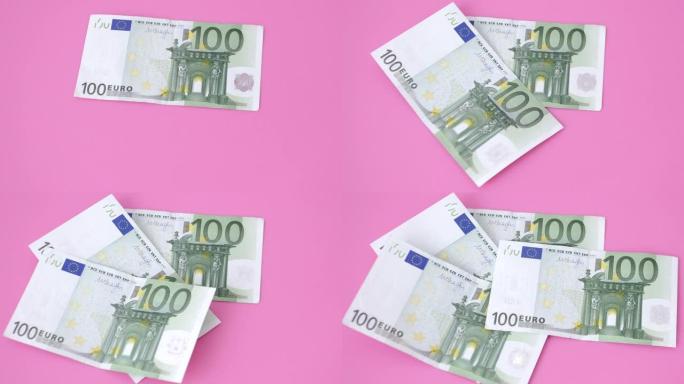 粉红色背景上的100欧元钞票。特写