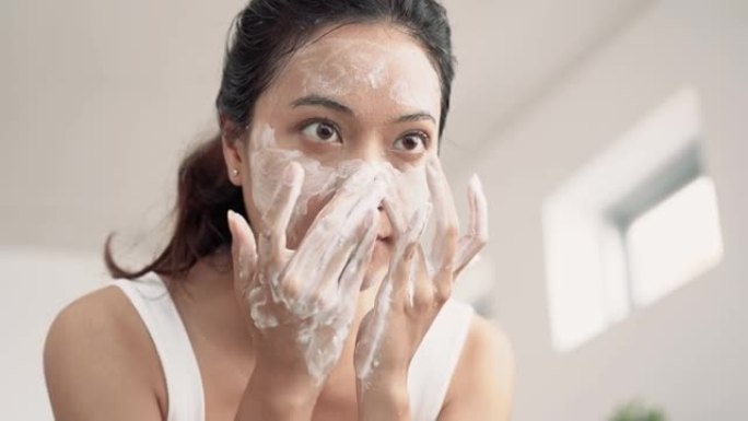 美丽的亚洲女性用水洗脸。