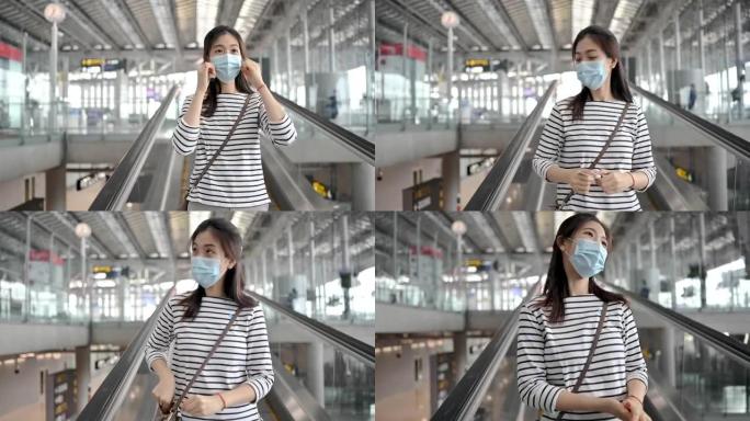 站在自动扶梯上的机场候机楼外，戴着口罩的亚洲旅行者妇女到登机口旅行。新常态出行概念。