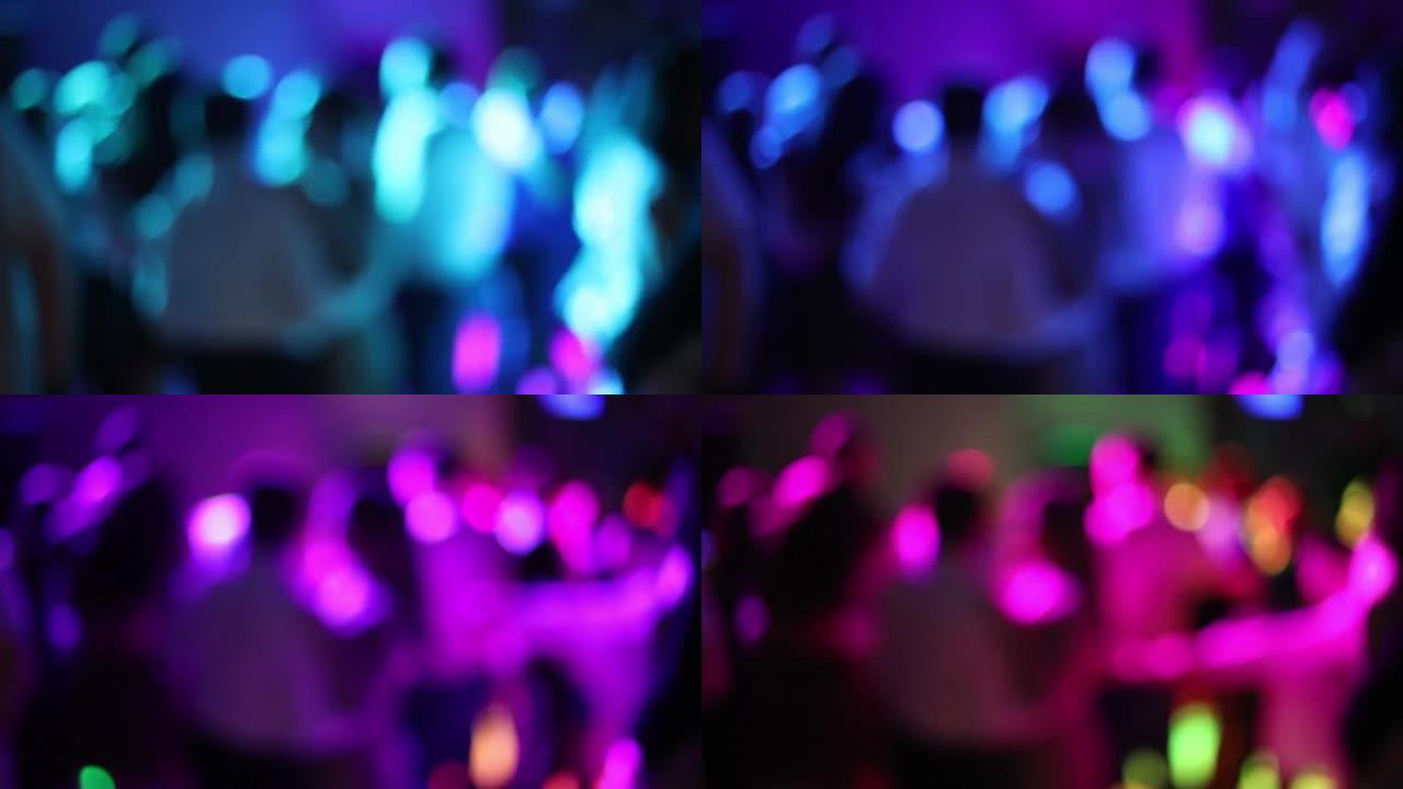 夜总会派对上跳舞的人的轮廓模糊。软聚焦，慢动作。霓虹灯激光灯派对。今晚玩得开心。舞蹈活动