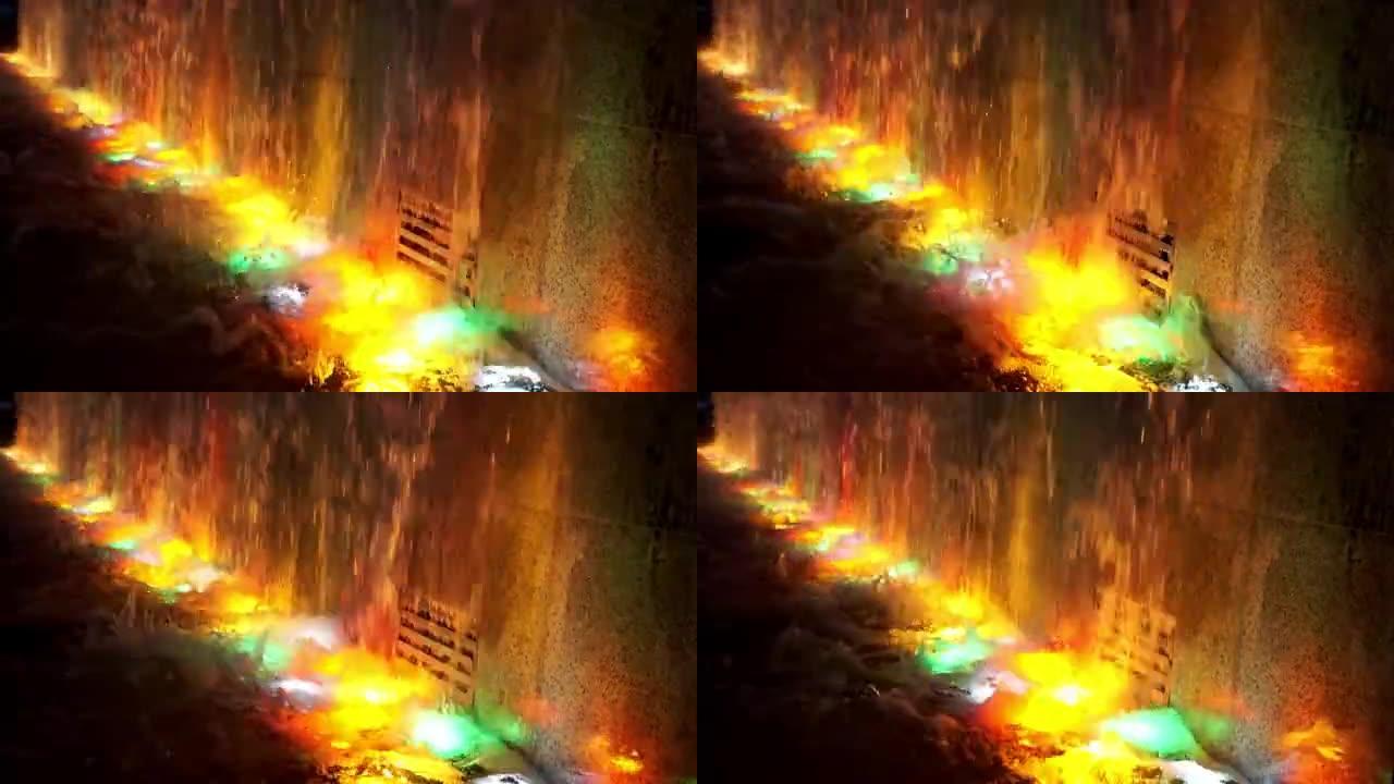 模糊的灯光甚至浇灌着充满照明的五彩水灯的瀑布。夜间喷泉