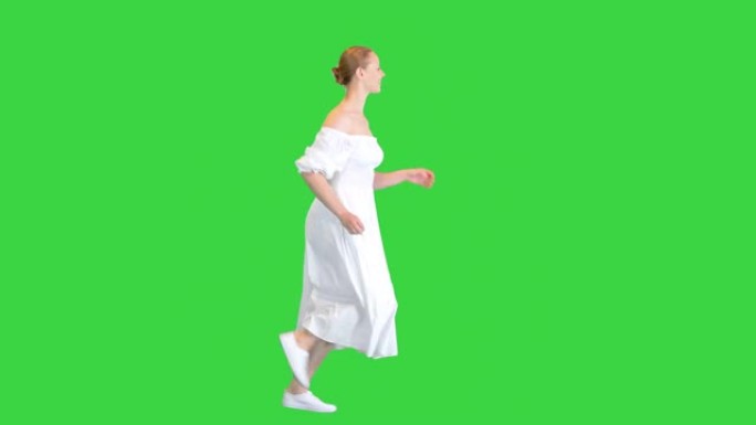 穿着白色连衣裙的年轻女子在绿色屏幕上奔跑，色键