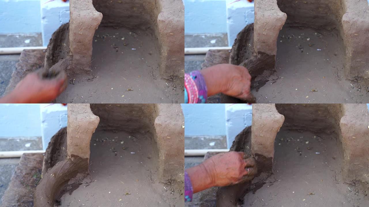 印度农村的女人手工制作粘土炉。古代艺术将粘土炉制成厨房燃料。