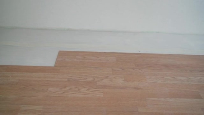 树下层压板的安装。橡木色镶木地板。地板的简单快速安装-连接层压锁-DIY浮动地板