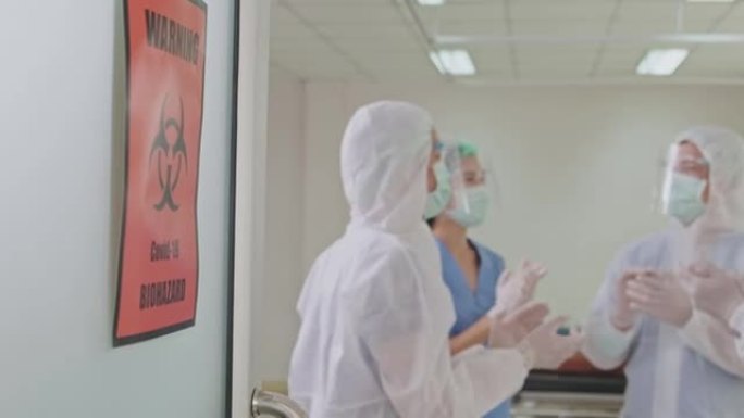一群穿着个人防护用品的亚洲医生在医院急诊室工作。对COVID感染的患者进行成功的急救和治愈后，专业的