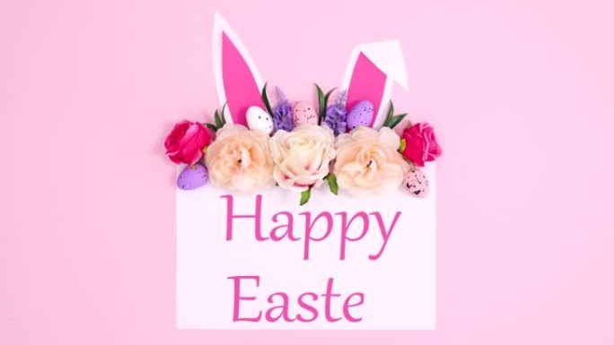 复活节快乐的文字写在纸上，上面写着绽放的花期和兔子的耳朵。停止运动
