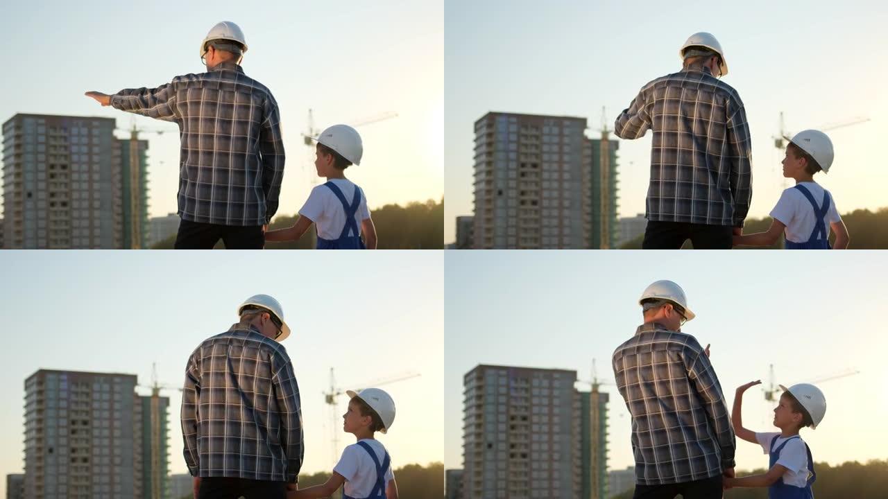 小男孩和他的父亲工程师建筑设计师，戴着安全帽，在现场背景新建筑和建筑起重机上
