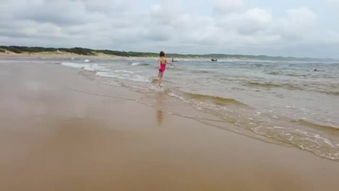 在浅海水域玩耍的年轻女孩
