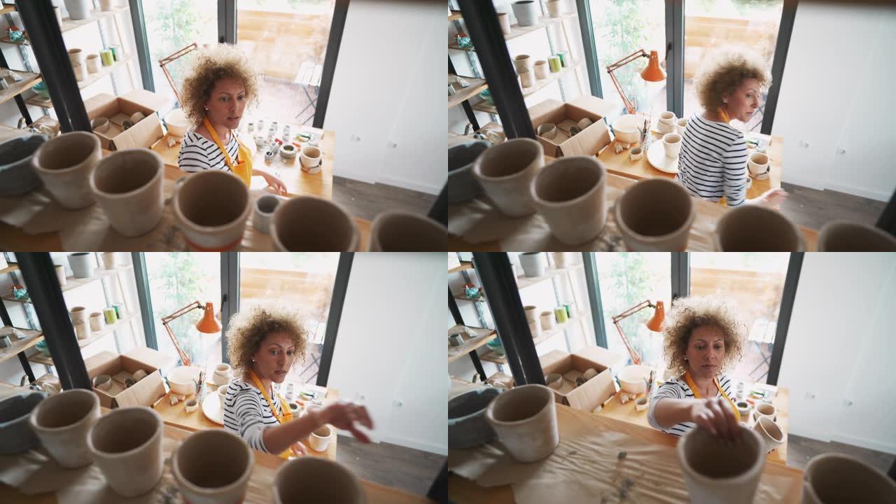 一位手工艺人在她的陶器工作室里布置了concete花盆