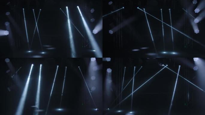 黑色演播室背景上舞台灯光的动态白色光束。探照灯旋转，转动并发出光束。全息图显示。假日和聚会的照明设备