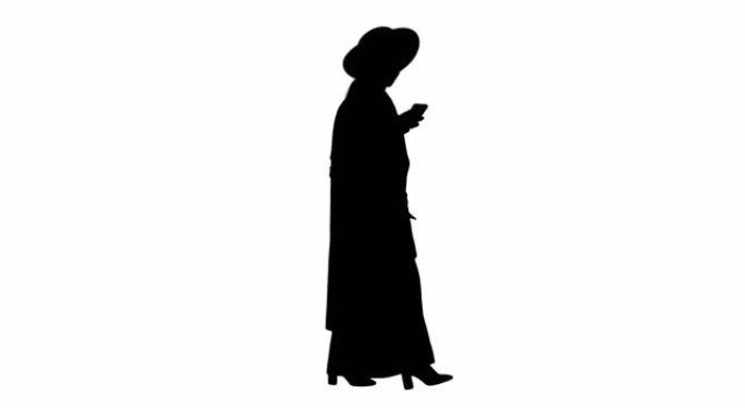 迷人的女人时尚的冬季服装在走路时用手机发短信，阿尔法频道